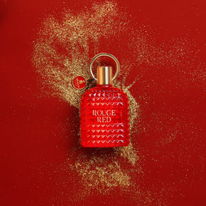 Rouge Red Eau De Parfum 100ml bottle on a red background with gold glitter, symbolizing elegance and boldness.