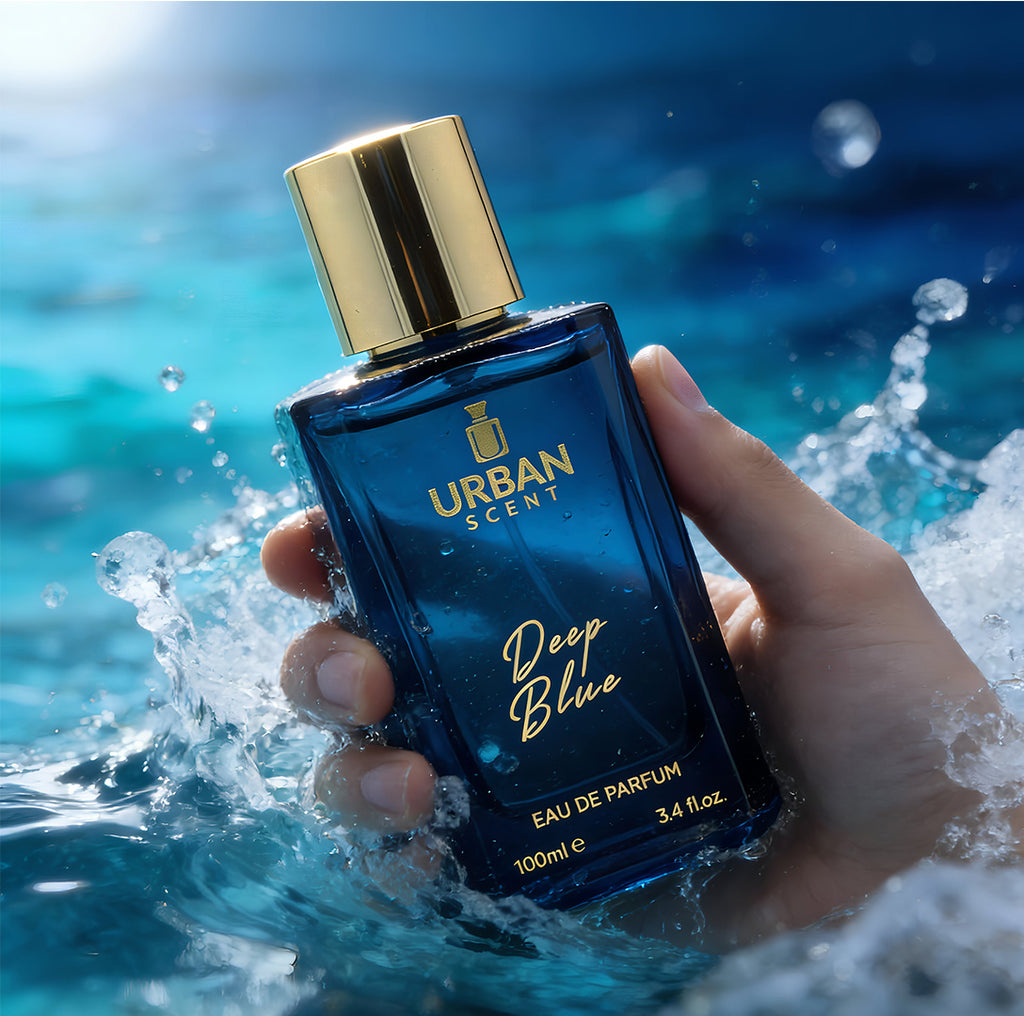Urban Scent Deep Blue Eau de Parfum held in hand with waves in the background, 100ml unisex fragrance.