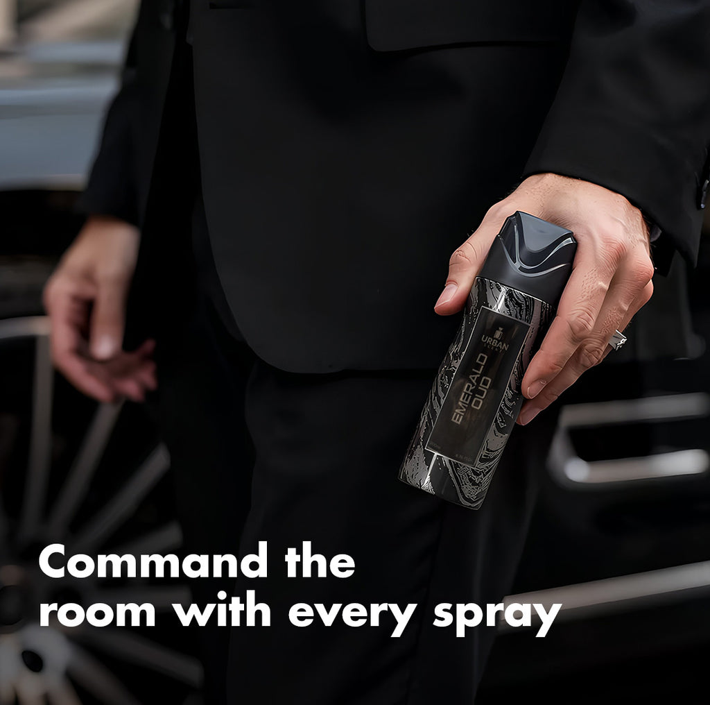 Urban Scent Emerald Oud perfume bottle held by a man in a suit, showcasing its luxurious design.