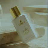 White Musk Eau De Parfum bottle from Urban Scent on a stone background, showcasing elegance and tranquility.